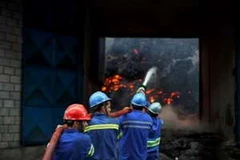 Lực lượng cứu hỏa khống chế ngọn lửa tại một kho hàng chứa đường ở cảng Santos ngày 18/10. (Ảnh: AFP )