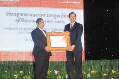 Thống đốc ngân hàng Quốc gia Campuchia Chea Chanto (trái) trao quyết định cho đại diện Sacombank Việt Nam. (Ảnh: Tuấn Anh/Vietnam+)