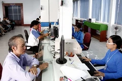 Khách đến lấy vé sau khi đặt vé qua mạng tại Ga Sài Gòn. (Ảnh: Hoàng Hải/TTXVN)