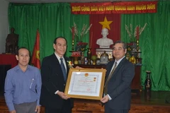 Đại sứ Ngô Đức Thắng trao tặng Huy chương kháng chiến hạng nhất cho gia đình ông Ninh Viết Minh, Việt kiều ở Bangkok. (Ảnh: Lê Minh Hưởng/Vietnam+)