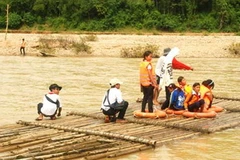 Các em học sinh qua sông Tang bằng bè tre. (Nguồn: vnexpress.net)