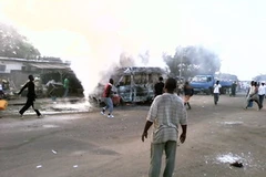 Một chiếc xe buýt bị đốt cháy trong cuộc xung đột. (Nguồn: THX/TTXVN)