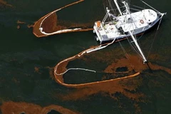 Tàu cứu hộ đang cố làm sạch các vệt dầu trên mặt biển. (Nguồn: The Huffington Post)