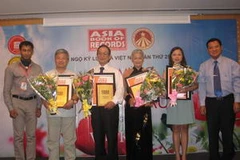 Ông Biswaroop Roy Chowhury, Tổng Giám đốc Tổ chức Kỷ lục châu Á trao bằng xác lập Kỷ lục châu Á cho 3 cá nhân và 1 tổ chức Việt Nam. (Ảnh: Huy Hiệp?Vietnam+)