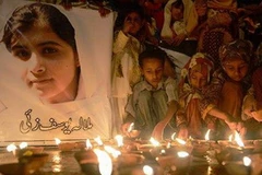 Trẻ em Pakistan thắp nến cầu nguyện cho cô bé Yousafzai. (Ảnh: AFP)