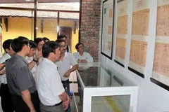 Khách tham quan chiêm ngưỡng tác phẩm mộc bản "Kỹ thuật của người An Nam". (Ảnh: Quốc Việt/Vietnam+)