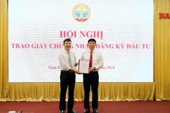 Trao Giấy chứng nhận đăng ký đầu tư dự án cho nhà đầu tư. (Ảnh: Thái Thuần/TTXVN)
