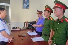 Kiểm sát viên tống đạt Quyết định phê chuẩn lệnh bắt tạm giam đối với Nguyễn Văn Nhưỡng. (Ảnh: TTXVN phát)