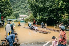 Tuyến đường thuộc thị trấn Pác Mjầu, huyện Bảo Lâm bị ngập sâu, người dân phải dùng bè mảng để di chuyển. (Ảnh: Bảo Chung/TTXVN phát)