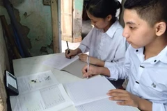 Nhiều gia đình khó khăn trong việc mua máy tính trong khi học sinh học trực tuyến trên điện thoại dễ bị ảnh hưởng thị lực. Không ít trường hợp hai học sinh phải học chung trên một thiết bị. (Ảnh: TTXVN phát)