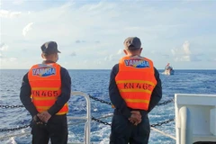 Tàu cá BTh 99367 TS (phải) được tàu Kiểm ngư lai kéo trên vùng biển Trường Sa. (Ảnh: TTXVN phát)