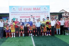 Đại diện các cầu thủ của 9 đội bóng lên nhân hoa và cờ lưu niệm. (Ảnh: Phạm Kiên/TTXVN)