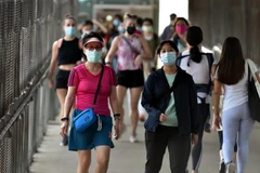 Người dân đeo khẩu trang phòng lây nhiễm COVID-19 tại Hong Kong (Trung Quốc). (Ảnh: THX/TTXVN)