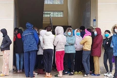 Công nhân chen nhau làm thủ tục xét nghiệm nhanh tại trạm y tế phường Bình Minh, thị xã Nghi Sơn (Thanh Hóa). (Ảnh: Trịnh Duy Hưng/TTXVN)