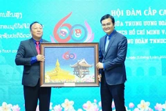 Đồng chí Bùi Quang Huy, Bí thư thứ nhất Trung ương Đoàn TNCS Hồ Chí Minh trao tặng phẩm cho đồng chí Monxay Laomuaxong, Bí thư Trung ương Đoàn Thanh niên Nhân dân cách mạng Lào. Ảnh: Minh Đức - TTXVN