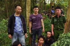 Ba đối tượng trồng cây thuốc phiện (ngồi) bị tạm giữ hình sự cùng số tang vật. (Ảnh: TTXVN)