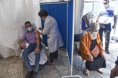 Nhân viên y tế tiêm vaccine phòng COVID-19 cho người dân tại Algiers (Algeria). (Ảnh: AFP/TTXVN)