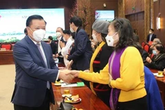 Ủy viên Bộ Chính trị, Bí thư Thành ủy Hà Nội Đinh Tiến Dũng gặp gỡ các đại biểu dự buổi gặp mặt. (Ảnh: Nguyễn Cúc/TTXVN)