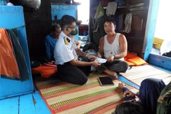 Cán bộ, chiến sỹ tàu 278 thuộc Vùng 2 Hải quân tặng quà hỗ trợ cho ngư dân bị nạn trên biển, ngày 31/7/2022. (Ảnh: TTXVN phát)