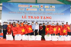 Tặng cờ, túi sơ cấp cứu, phao cứu sinh đa năng cho ngư dân Bình Thuận. (Ảnh: Nguyễn Thanh/TTXVN)