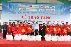 Tặng cờ, túi sơ cấp cứu, phao cứu sinh đa năng cho ngư dân Bình Thuận. (Ảnh: Nguyễn Thanh/TTXVN)