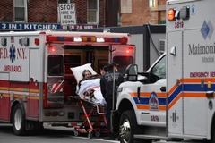 Nhân viên y tế chuyển bệnh nhân COVID-19 tới trung tâm y tế tại New York (Mỹ). (Ảnh: AFP/TTXVN)