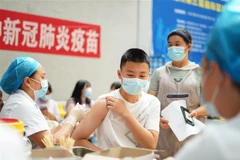 Nhân viên y tế tiêm vaccine ngừa COVID-19 cho học sinh tại Quý Châu (Trung Quốc). (Ảnh: THX/TTXVN)