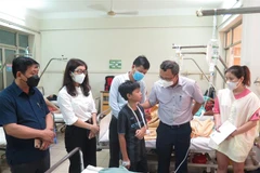Ông Khuất Việt Hùng, Phó Chủ tịch chuyên trách Ủy ban An toàn giao thông Quốc gia (thứ hai, phải) thăm hỏi nạn nhân bị thương nặng đang nằm điều trị tại Bệnh viện Đa khoa tỉnh Khánh Hòa. (Ảnh: Phan Sáu/TTXVN)