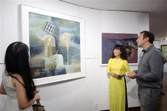 Khách nước ngoài xem triển lãm mỹ thuật "Hội ngộ." (Ảnh: Trần Lê Lâm/TTXVN)