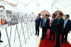 Các đại biểu tham quan Trưng bày ảnh "Khát vọng chiến thắng" của Thông tấn xã Việt Nam. (Ảnh: Phạm Kiên/TTXVN)