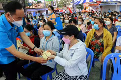 Lãnh đạo Liên đoàn Lao động thành phố trao phiếu mua hàng miễn phí cho công nhân người lao động có hoàn cảnh khó khăn được vui xuân, đón Tết tại công viên Văn Lang, Quận 5 (Thành phố Hồ Chí Minh), ngày 23/1/2022. (Ảnh: Thanh Vũ/TTXVN)