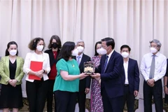 Ông Phan Văn Mãi, Chủ tịch UBND Thành phố tặng quà lưu niệm cho bà Manuel V.Ferro, Phó Chủ tịch Ngân hàng Thế giới Toàn cầu (World Bank). Ảnh: Xuân Khu-TTXVN
