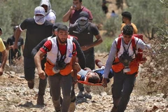 Chuyển người biểu tình Palestine bị thương trong xung đột với binh sỹ Israel tại thị trấn Beita, gần Nablus, khu Bờ Tây ngày 9/7/2021. (Ảnh: AFP/TTXVN)