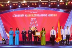 Phó Chủ tịch nước Võ Thị Ánh Xuân trao Huân chương Lao động hạng Nhì cho đại diện Cục Báo chí. (Ảnh: Tuấn Đức/TTXVN)