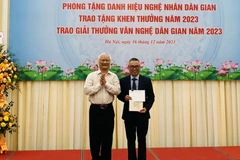 Giáo sư, Tiến sỹ Lê Hồng Lý, Chủ tịch Hội Văn nghệ Dân gian Việt Nam trao Giải Nhì A (không có Giải Nhất) cho tác giả Nguyễn Tiến Dũng. (Ảnh: Phương Hà/TTXVN)