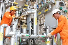 Hiệu chỉnh thiết bị vừa được lắp đặt tại nhà máy. (Ảnh: Hà Thái/TTXVN)