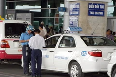 Cán bộ Thanh tra giao thông kiểm tra xe taxi đón khách tại sân bay. (Ảnh: Thanh Phàn/TTXVN) 