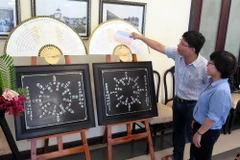 Các đại biểu tham quan trưng bày Thơ văn trên kiến trúc cung đình Huế tại hội nghị. (Ảnh: Quốc Việt/Vietnam+)