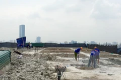 Công nhân Công ty Cổ phần Tập đoàn Phương Bắc dùng máy khoan phá dỡ phần trần bêtông. (Ảnh: Minh Nghĩa/TTXVN)