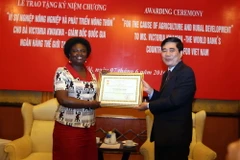 Bộ trưởng Nông nghiệp và Phát triển Nông thôn Cao Đức Phát trao kỷ niệm chương cho bà Victoria Kwakwa. (Ảnh: Vũ Sinh/ TTXVN) 