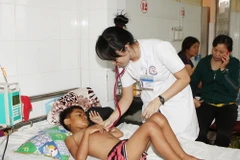 Y, bác sỹ thăm khám cho bệnh nhân sốt xuất huyết tại Bệnh viện Đa khoa tỉnh Đắk Lắk. (Ảnh: Dương Giang/TTXVN)