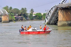 Lực lượng chức năng tiến hành khảo sát hiện trường trước khi tiến hành trục vớt. (Ảnh: Công Phong/TTXVN)