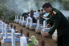 Thắp hương viếng mộ các Anh hùng, liệt sỹ tại Nghĩa trang Đường 9. (Ảnh: Trọng Đức/TTXVN) 