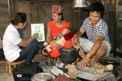 Nhân viên y tế thôn bản hướng dẫn bà mẹ chăm sóc sơ sinh tại xã Cà Tạ, huyện miền núi Kỳ Sơn, Nghệ An. (Ảnh: Dương Ngọc/TTXVN)