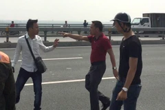 Nhà báo Quang Thế (áo trắng) bị hành hung khi đang tác nghiệp trên cầu Nhật Tân. (Nguồn: Báo Tuổi Trẻ)