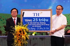 Chủ tịch Ủy ban Trung ương MTTQ Việt Nam Nguyễn Thiện Nhân và Bộ trưởng Bộ Giáo dục và Đào tạo Phùng Xuân Nhạ đón nhận tượng trưng quà của Công ty Sữa TH trao tặng Chương trình Sữa học đường-Vì tầm vóc Việt. (Ảnh: Nguyễn Dân/TTXVN) 