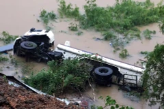 Chiếc xe bồn bị lật nằm gọn dưới sông Cầu. (Ảnh: Đức Hiếu/TTXVN)