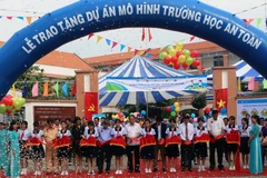 Nghi thức cắt băng trao tặng Mô hình trường học an toàn thứ hai tại Trường trung học cơ sở Long Trường. (Ảnh: Hoàng Hải/Vietnam+)