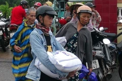 Người dân nhận gạo hỗ trợ. (Ảnh: Trịnh Bang Nhiệm/TTXVN)