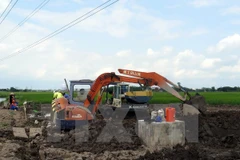 Đơn vị kiểm định chất lượng bêtông tiến hành khoan trụ bêtông cột điện cao thế để lấy mẫu kiểm định chất lượng. (Ảnh: Văn Đạt/TTXVN)